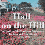 Hall on the Hill cover. Photograph of the Mechanics Hall building with pink pigface flowers in the foreground.